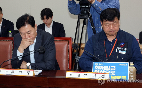 22일 정부세종청사에서 열린 최저임금위원회 1차 전원회의에서 최저임금위원회 사용자위원인 류기정 한국경영자총협회 전무(왼쪽)와 근로자위원인 류기섭 한국노총 사무총장이 관련 자료를 들여다보고 있다. 연합뉴스