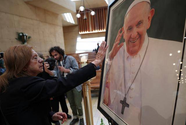 21일 미국 캘리포니아주 로스앤젤레스에 있는 성모 천사 대성당을 찾은 한 신도가 프란치스코 교황의 초상화를 보며 인사를 하고 있다. 로스앤젤레스=로이터 연합뉴스