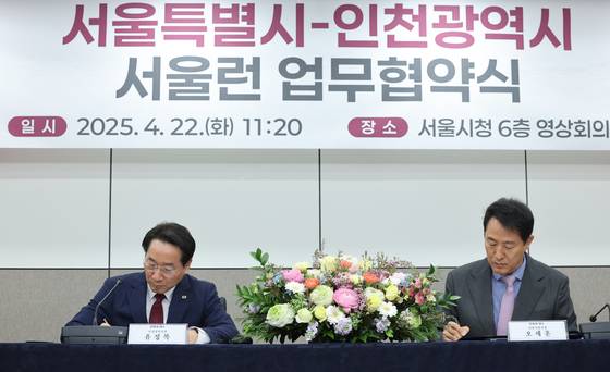 오세훈 서울시장과 유정복 인천시장이 22일 오전 서울시청에서 열린 '사교육비 경감 및 교육격차 해소를 위한 서울시-인천시 서울런 업무협약식'에서 협약서에 서명하고 있다.  [뉴스1]