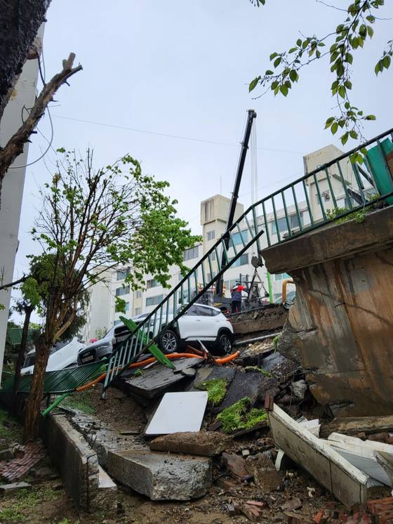 22일 오후 경기 남양주시 화도읍의 한 아파트 단지 주차장 옹벽이 붕괴되면서 주차돼 있던 차량들이 옹벽 아래로 추락했다. 사진 경기북부소방재난본부