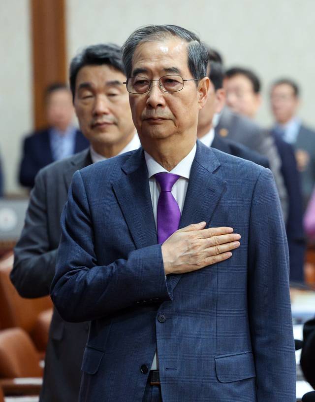 한덕수 대통령 권한대행 국무총리가 22일 오전 정부서울청사에서 열린 국무회의에서 국기에 대한 경례를 하고 있다.  연합뉴스