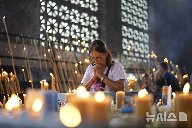 [아파레시다=AP/뉴시스] 21일(현지 시간) 브라질 아파레시다의 성모 아파레시다 성지에서 한 여성이 프란치스코 교황을 추모하며 기도하고 있다. 2025.04.22.