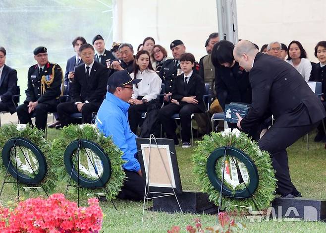 [부산=뉴시스] 하경민 기자 = 캐나다 한국전 참전용사 고(故) 윌리엄 존 크라이슬러씨의 안장식이 열린 22일 부산 남구 유엔기념공원 참전용사묘역에서 유가족이 유해함을 안장하고 있다.  유엔기념공원에는 고인을 포함해 총 14개국 2331명의 한국전 유엔군 참전용사가 잠들어 있다. 2025.04.22. yulnetphoto@newsis.com