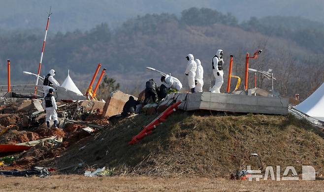 [무안=뉴시스] 김선웅 기자 = 2일 전남 무안국제공항 제주항공 여객기 참사 현장에서 항공·철도사고 조사위원회(ARAIB) 관계자들이 로컬라이저(방위각 표시 시설)가 설치된 콘크리트 둔덕을 조사하고 있다.  2025.01.02. mangusta@newsis.com