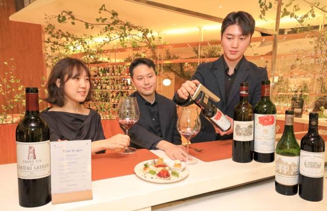 현대백화점 압구정본점 지하 1층에 위치한 ‘프리미엄 글라스 와인 바’에서 고객들이 최고급 와인에 해당하는 5대 샤토를 글라스 와인으로 즐기고 있다. 사진 제공=현대백화점