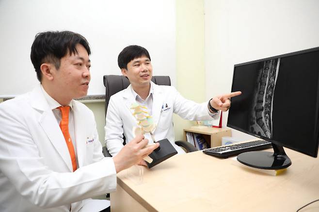 힘찬병원 척추클리닉 김민규 원장(왼쪽)과 허준영 원장이 요추 추간판탈출증(허리디스크) 환자의 치료법에 대해 의논하고 있다. (사진=힘찬병원)
