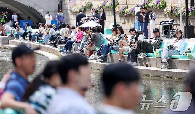 낮 최고기온이 25도를 기록하는 등 초여름 날씨를 보인 23일 오후 서울 중구 청계천을 찾은 시민들이 독서를 하고 있다. 2025.4.23/뉴스1 ⓒ News1 김성진 기자