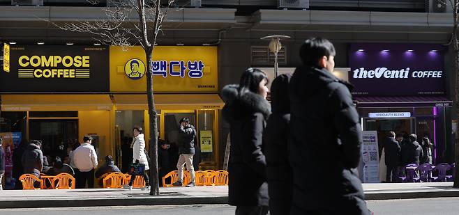 저가 커피 판매점이 밀집한 서울 종로구의 한 상가 앞으로 시민들이 걸어가고 있다. /연합뉴스
