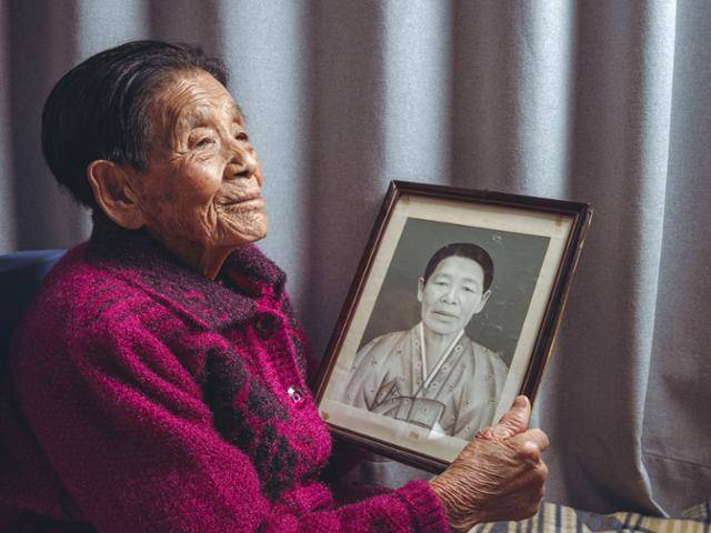 지난달 15일 일본군 '위안부' 피해 생존자인 박필근(97) 할머니가 경북 포항시 북구 죽장면 자택에서 한국일보·코리아타임스와 인터뷰를 하고 있다. 손에 든 액자의 사진은 과거 박 할머니 자신의 모습이다. 포항=심현철 코리아타임스 기자