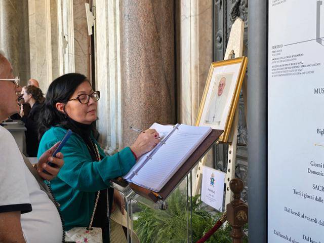 이탈리아 로마의 산타 마리아 마조레 대성당 내에 마련된 방명록에 22일 성당 방문자들이 선종한 프란치스코 교황을 향한 메시지를 적고 있다. 로마=신은별 특파원