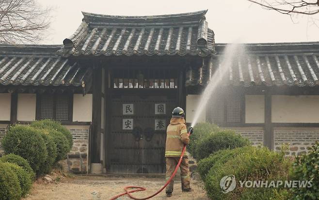 경북 안동 하회마을에서 소방대원이 산불 불씨가 옮겨붙지 않도록 마을 곳곳에 물을 뿌리고 있다. 연합뉴스