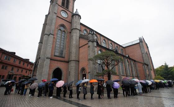 22일 명동대성당에 마련된 프란치스코 교황 분향소를 찾은 시민들이 차례를 기다리고 있다. 오는 26일 바티칸에서 거행될 장례식에는 염수정 추기경과 이용훈 주교, 임민균 신부가 참석한다. [사진 사진공동취재단]