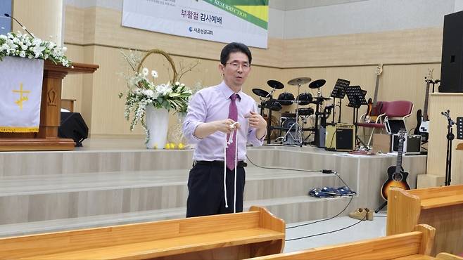 김종흔 목사가 끈을 활용한 가스펠매직으로 예수와 하나됨을 설명하고 있다.