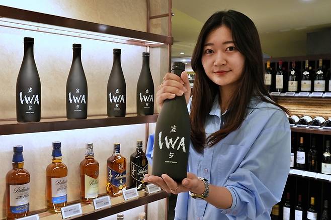 롯데백화점 본점 지하 1층 와인매장에서 상품을 들고 있는 모습.[사진제공=롯데백화점]