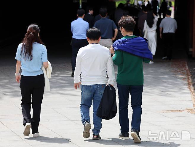 [서울=뉴시스] 이영환 기자 = 서울의 낮기온이 24도까지 오르며 초여름 날씨를 보인 23일 오후 서울 영등포구 여의도공원에서 시민들이 외투를 손에들고 이동하고 있다. 2025.04.23. 20hwan@newsis.com