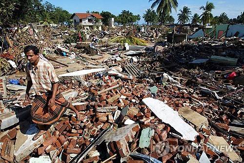 2004년 지진해일로 쑥대밭이 된 함반토타 마을을 한 남성이 지나가고 있다. [EPA=연합뉴스]
