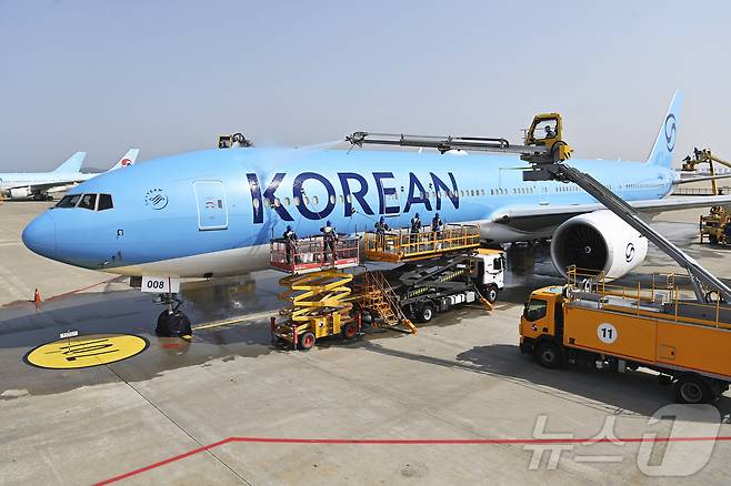 24일 오전 인천 중구 인천국제공항 대한항공 격납고에서 직원들이 봄을 맞아 항공기 동체를 세척하고 있다. 이날 세척한 항공기는 보잉 777-300ER 기종으로 대한항공의 새 도장이 적용된 기체다. (공동취재) ⓒ News1 장수영 기자