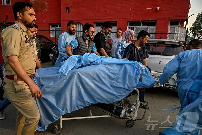 22일(현지시간) 인도 스리나가르 아난트나그의 한 병원에서 구급대원과 경찰이 부상당한 관광객을 이송하고 있다. 이날 카슈미르에서 무장괴한이 관광객을 상대로 총격을 가해 최소 28명이 사망했다. 25.04.22 ⓒ AFP=뉴스1 ⓒ News1 김예슬 기자