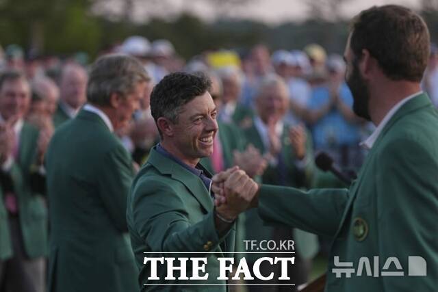 마스터스에서 우승한 로리 맥길로이(가운데)에게 디펜딩 챔피언 스코티 셰플러가 축하의 악수를 건네고 있다./AP. 뉴시스