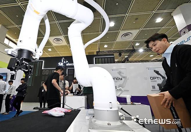 국내 최고 정보통신기술(ICT) 축제 '월드IT쇼(WIS) 2025가 24일 서울 강남구 코엑스에서 열렸다. 참관객이 뉴로메카의 협동로봇 '인디'를 살펴보고 있다.  이동근기자 foto@etnews.com