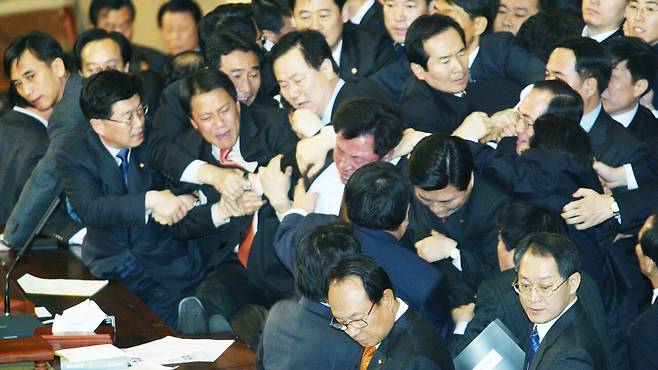 노무현 전 대통령 탄핵소추안이 처리되던 날 국회 본회의장의 모습. 의장석을 점거하고 있던 열린우리당 의원들이 국회 경호원과 야당 의원들에게 끌려 내려오고 있다. [중앙포토]