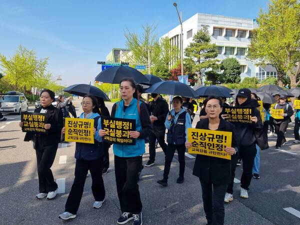 인천의 교원 단체가 24일 검은 우산을 들고 도보행진 시위를 벌이고 있다. 정성식 기자