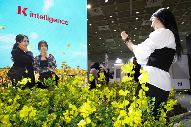 KT  모델들이 KT 2025 월드IT쇼 전시부스에서 각종 AI 기술을 체험하고 있다. /사진=KT