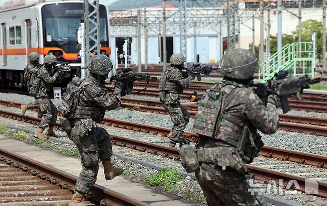 [부산=뉴시스] 하경민 기자 = 2025년 충무훈련의 하나로 '도시철도 피해복구 종합 실제훈련'이 열린 23일 부산 금정구 도시철도 1호선 노포차량정비창에서 군사경찰 대테러특임대가 테러범을 제압하고 있다.  전시 적 공격으로 인한 도시철도 시설피해 발생에 대비한 민·관·군·경·소방 합동훈련에는 53사단 부산여단과 부산교통공사, 금정구청, 금정소방서, 보건소, 부산항만공사, 금정결찰서 등 7개 기관 200여 명이 참가했다. 2025.04.23. yulnetphoto@newsis.com