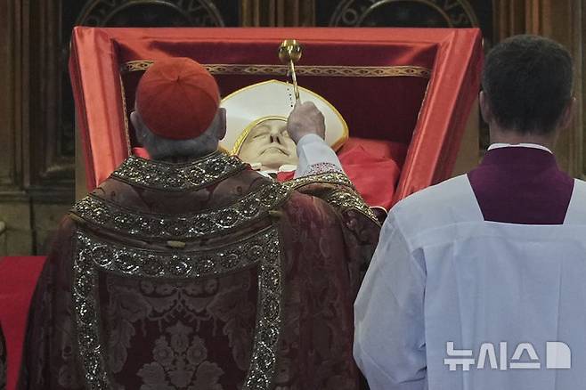 [바티칸시국=AP/뉴시스] 23일(현지 시간) 바티칸의 성 베드로 대성당에서 궁무처장 케빈 조셉 패럴 추기경이 프란치스코 교황의 시신을 축복하고 있다. 프란치스코 교황의 시신은 사흘간 대성당에 안치돼 일반 신자들의 조문을 받는다. 2025.04.23.