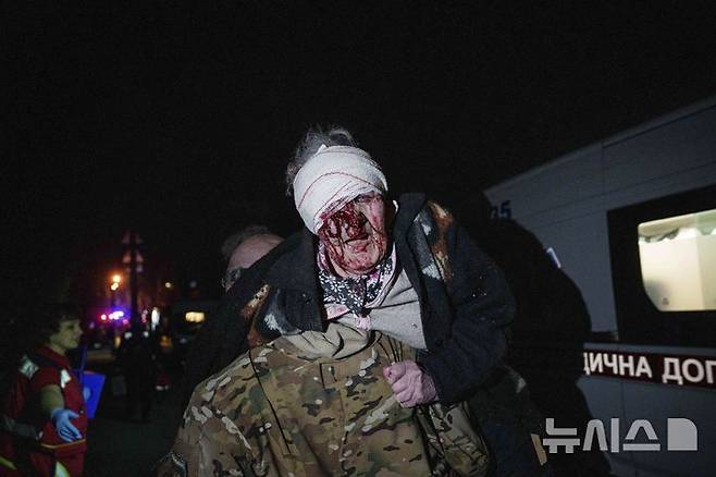 [키이우=AP/뉴시스] 24일(현지 시간) 우크라이나 키이우의 주택가에서 우크라이나 군인이 러시아의 공습으로 부상한 여성을 대피시키고 있다. 비탈리 클리치코 키이우 시장은 러시아의 대규모 공격으로 최소 2명이 숨지고 6명의 어린이와 임산부 등 54명이 부상했다고 밝혔다. 2025.04.24.