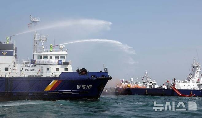 [부산=뉴시스] 하경민 기자 = 항공기 해상 불시착 상황을 가정한 수난대비 합동 구조훈련이 열린 24일 부산 강서구 진우도 인근 해상에 불시착한 모의항공기(500t급 경비함)에서 불이 나자 해경이 진화작업을 펼치고 있다. 이날 훈련에는 남해지방해양경찰청, 창원해양경찰서 등 13개 유관기관·단체에서 총 14척의 선박과 헬기 1기가 동원됐다. 2025.04.24. yulnetphoto@newsis.com