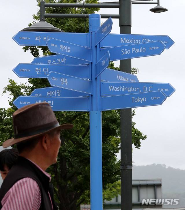 [서울=뉴시스]박주성 기자 = 24일 오후 서울 세종문화회관 계단 앞에 평양을 비롯해 세계 15개 주요도시로 가는 방향과 거리가 적힌 파란색 기동의 '세계도시 이정표'가 설치되어 있다.  이정표가 자리하는 곳은 명동·이태원 등 외국인 관광객이 주로 찾는 보행밀집지역(10개소), 도심 속 자연을 느낄 수 있는 서울시내 주요 공원(5개소)과 한강공원(5개소)이다. 서울광장, 광화문, 동대문디자인플라자(DDP) 등 13개소는 이미 설치 완료했고, 나머지 7개소는 8월 말까지 설치한다. 2018.08.24. park7691@newsis.com
