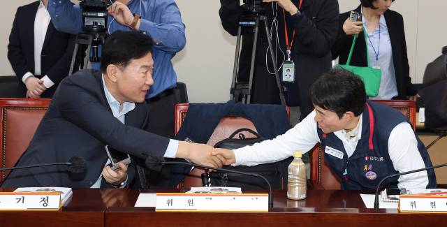 ▲최저임금위원회 사용자위원인 류기정 한국경영자총협회 전무(왼쪽)와 근로자위원인 이미선 민주노총 부위원장이 22일 정부세종청사에서 열린 내년도 최저임금 수준을 결정하기 위한 최저임금위원회 1차 전원회의에서 만나 악수하고 있다. ⓒ연합뉴스