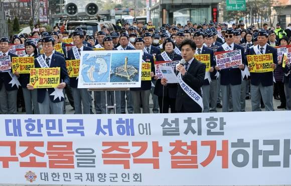 재향군인회원들이 31일 오전 서울 중구 주한 중국대사관 인근에서 중국이 서해에 무단으로 설치한 인공구조물 철거를 촉구하고 있다. 중국이 서해 한·중 잠정조치수역(PMZ)에 설치한 철골 구조물 ‘선란 1·2호’는 중국 산둥성 기업의 연어 양식장으로 소개되지만, 중국이 해양 관할권을 주장해온 동경 124도선 서쪽에 위치해 단순한 민간 시설을 넘어선다는 지적이 나온다. 2025.3.31. 뉴스1