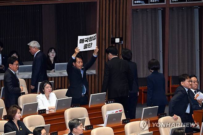 한덕수 권한대행 추경 시정연설에 항의 (서울=연합뉴스) 진보당 윤종오 의원이  24일 서울 여의도 국회 본회의장에서 한덕수 대통령 권한대행 국무총리의 추가경정예산안 시정연설 때 항의 팻말을 들어보이고 있다. 2025.4.24 [국회사진기자단] photo@yna.co.kr