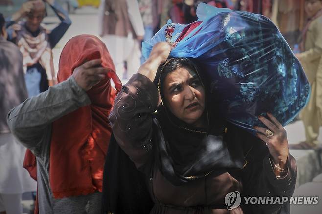 아프가니스탄 수도 카불서 짐을 나르는 여성 [AP 연합뉴스 자료사진. 재판매 및 DB 금지]