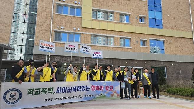 ▲ 법무부 청소년범죄예방위원 부천지역협의회 김포지구가 24일 김포한강신도시 구래동 김포 호수고교 정문 앞에서 교사·재학생들과 함께 학교폭력예방 캠페인을 하고 있다./사진제공=범방위 김포지구