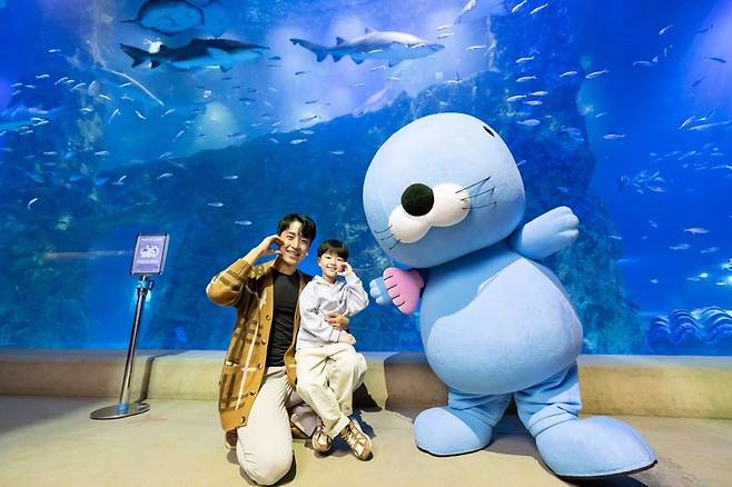 롯데월드 아쿠아리움을 찾은 고객들이 보노보노 캐릭터와 함께 사진을 찍고 있다. 롯데월드 제공