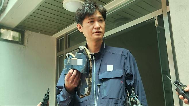 지난 21일 방화 범죄가 발생한 서울 봉천동 한 아파트 현관에서 25일 피해자의 아들 정아무개(45)씨가 피해자가 평소 신었던 ‘소음방지 슬리퍼’를 보여주고 있다. 장종우 기자