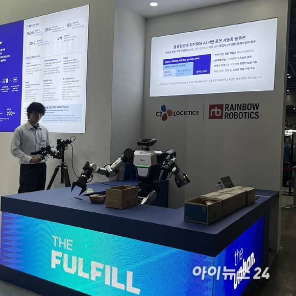 CJ대한통운 TES물류기술연구소 한 연구원이 양팔 로봇을 조정해 움직이고 있다. [사진=권서아 기자]