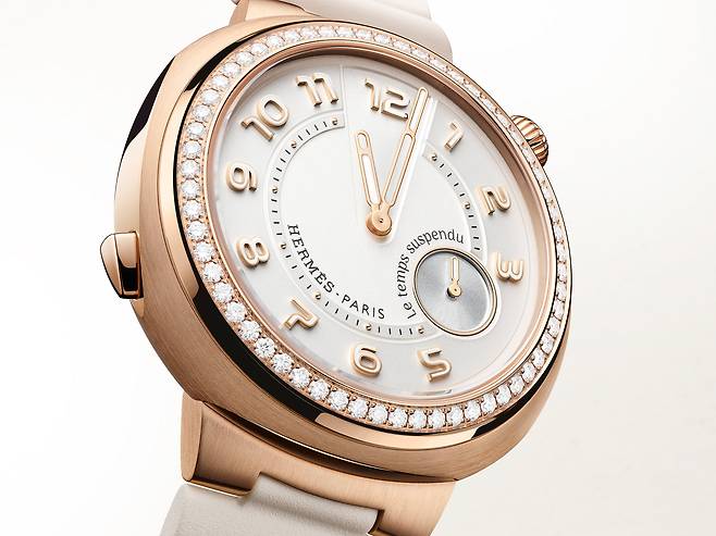베젤에 다이아몬드를 세팅한 에르메스 컷 르 땅 서스팡뒤 로즈 골드 워치. 8시 방향 푸시버튼을 누르면 시침과 분침이 12시 방향에 모여 멈춘다. 4시 방향 24초 인디케이터 위 바늘은 반시계방향으로 돈다. 사진 에르메스