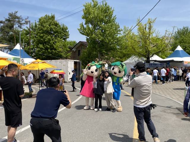 ▲ 지난해 강원n홍천 산나물 축제장에서 축제 캐릭터 ‘곰이’, ‘명이’와 사진을 찍고 있는 방문객 모습
