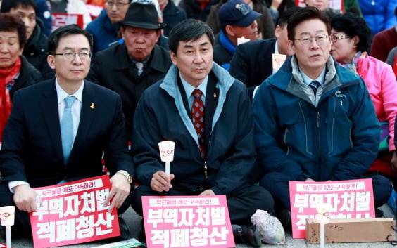 제19대 대통령선거 더불어민주당 경선 후보로 출마한 이재명 당시 성남시장(오른쪽)이 2017년 3월 광주 동구 금남로에서 열린 촛불집회에 참석해 앉아 있다. 가운데는 이재명 캠프 선거대책위원장이었던 이종걸 의원이고 왼쪽이 총괄선대본부장이었던 정성호 의원. 연합뉴스