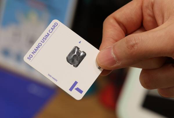 사진은 25일 서울 한 SKT 대리점에서 한 직원이 사용한 유심 카드를 들어 보이고 있다. 연합뉴스