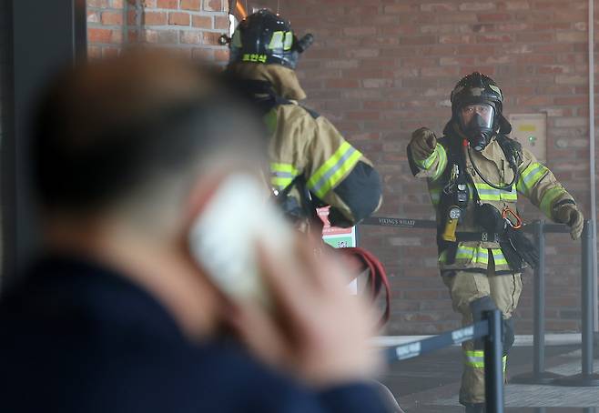Firefighters inspect the site of the fire that broke out inside the Coex convention center in southern Seoul on Friday. (Yonhap)