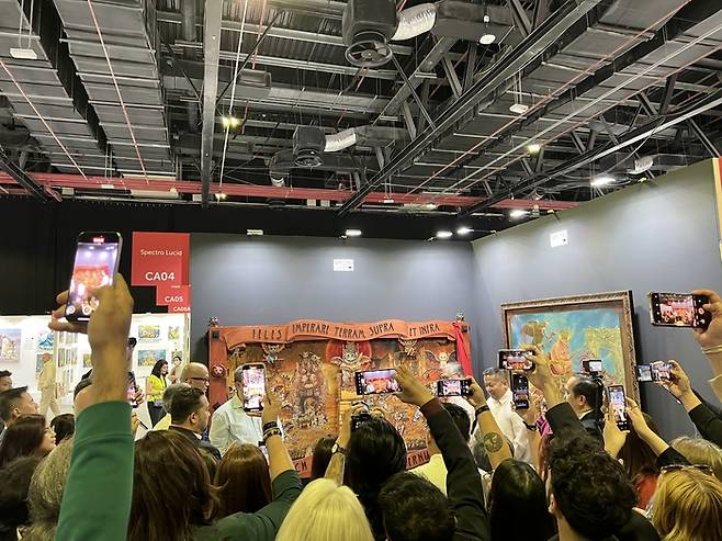 예술을 잘 모르는 초보자라 해도 그저 천천히 걷고, 마음을 끄는 그림 앞에서 멈춰 서 보는 것만으로도 이 공간은 충분히 즐겁다. 그림 앞에서 사람들이 공개 직전에 몰려들어 폰으로 찍고 있는 모습.