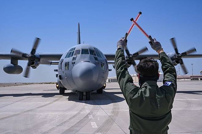[서울=뉴시스] 공군은 지난 21일부터(현지 시간) UAE 알 다프라 공군기지에서 열리는 '2025 데저트 플래그'에 참가해 화물 투하, 비포장 활주로 착륙 훈련 등을 실시하고 있다. 24일에는 UAE군사훈련협력단(아크부대)과 처음으로 합동고공강하 훈련도 실시했다.사진은 이륙에 앞서 C-130H 수송기를 유도하고 있는 임무요원. (사진=공군 제공) 2025.04.25. photo@newsis.com *재판매 및 DB 금지