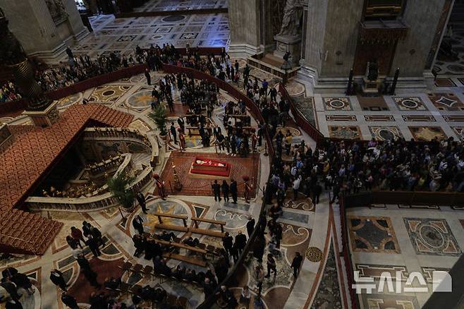 [바티칸시국=AP/뉴시스] 도널드 트럼프 미국 대통령이 프란치스코 교황 장례식에서 조문객 좌석 3열에 앉을 가능성이 높은 것으로 알려졌다. 영국 일간 텔레그래프는 24일(현지 시간) 2005년 요한 바오로 2세 장례식을 근거로 귀빈석 배치 예상 순서를 보도했다. 사진은 24일 프란치스코 교황 시신이 안치된 성베드로 대성당에서 신자들이 조문하는 모습. 2025.04.25.