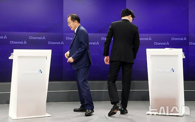 [서울=뉴시스] 국회사진기자단= 25일 오후 종로구 동아미디어센터 채널A스튜디오에서 국민의힘 대선 2차 경선 진출자인 한동훈, 홍준표(왼쪽) 후보가 기념촬영 후 자리로 돌아가고 있다. 일대일 맞수 토론은 2차경선 진출자 4명이 일대일 맞수 토론 형식으로 진행된다. photo@newsis.com