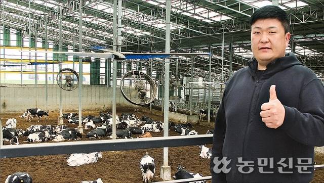 젖소농가 이종화 이정목장 대표가 축사 앞에서 엄지손가락을 치켜세우고 있다.